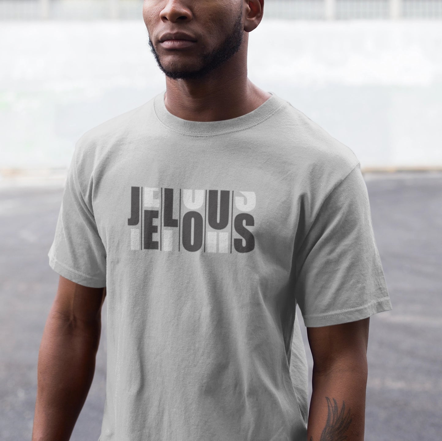 Man wearing a blue JELOUS Grid grey Tee with bold white print, casual short-sleeve 100% cotton regular fit t-shirt for men