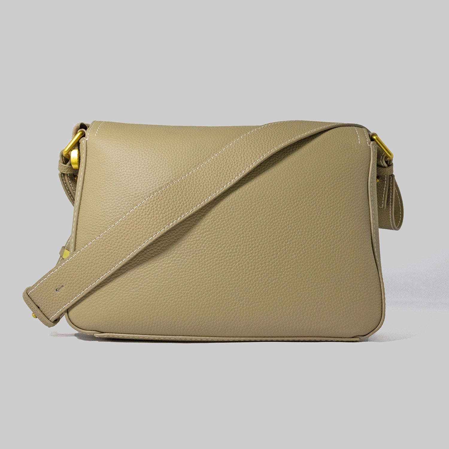 Beige genuine cowhide leather handbag named The Jelous Astra with a geometric front flap, magnetic closure, and two detachable straps.